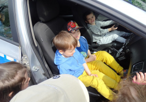 dzieci zwiedzają radiowóz policyjny
